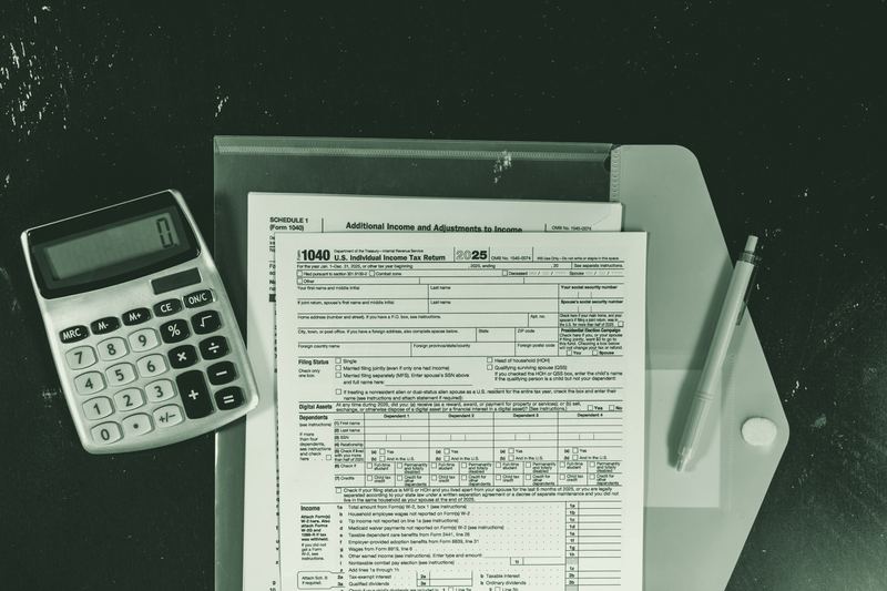 A calculator and paperwork on a dark desk